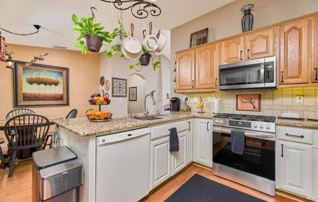 a kitchen with stainless steel appliances granite countertop a stove a sink and a microwave