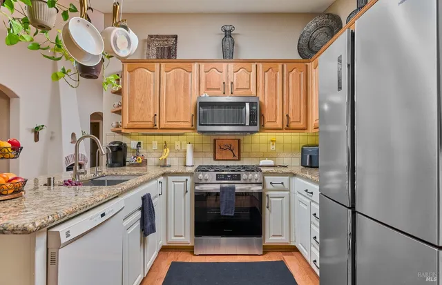 a kitchen with stainless steel appliances granite countertop a stove and cabinets