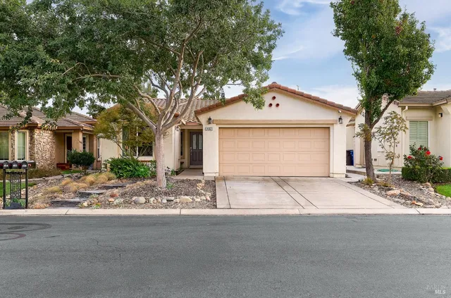 a front view of a house with yard and trees