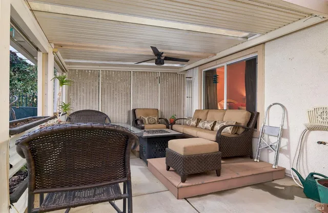 a living room with furniture a ceiling fan and a window