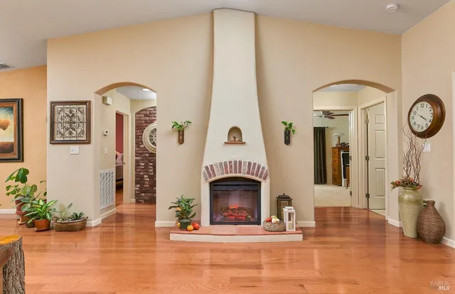 a view of a livingroom with a fireplace a flat screen tv and potted plants