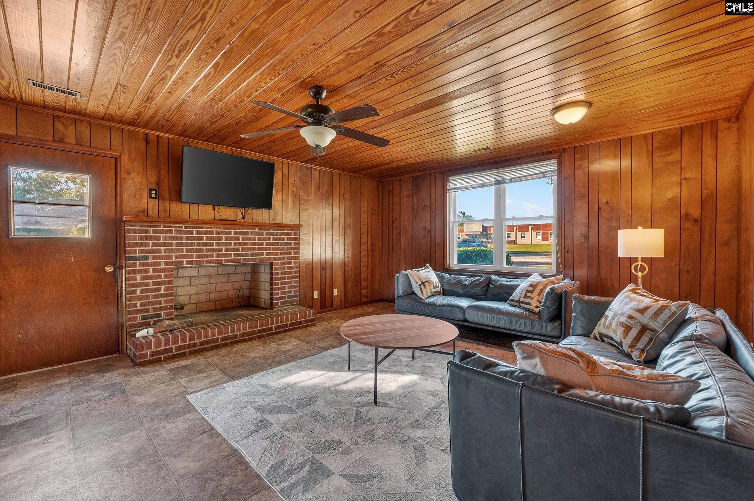 729 Magnolia Street Pelion, SC 29123 - Photo 20 of 32 a living room with furniture a fireplace and a flat screen tv
