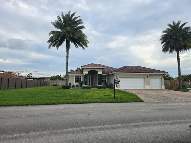 a front view of a house with a garden and yard
