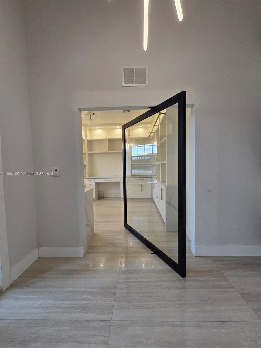 12944 Southwest 222nd Street Miami, FL 33170 - Photo 11 of 44 an empty room with wooden floor and door