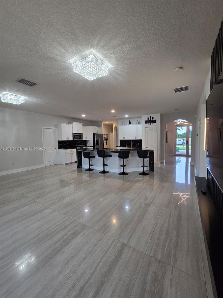 12944 Southwest 222nd Street Miami, FL 33170 - Photo 19 of 44 a living room with furniture and a chandelier