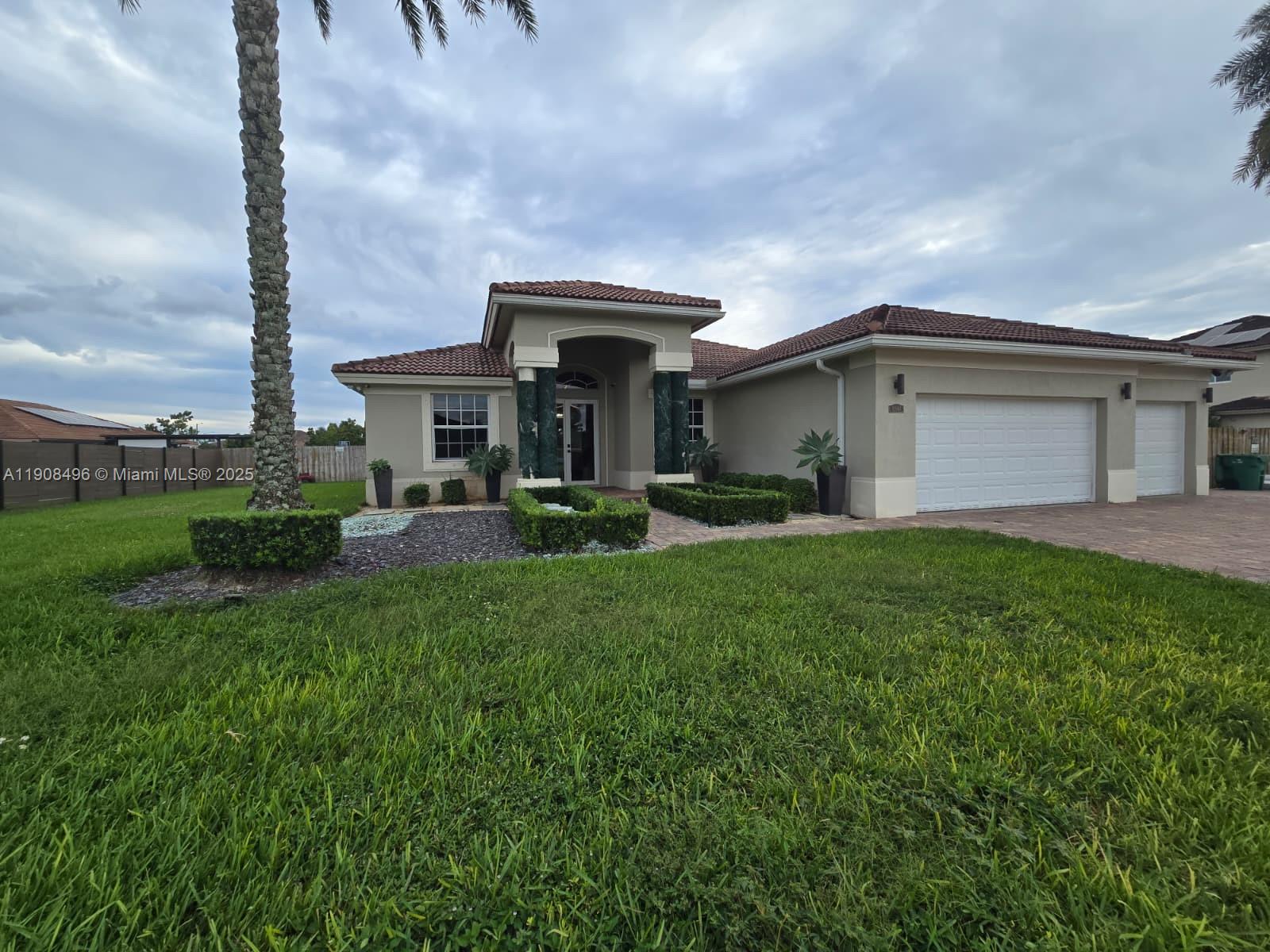 12944 Southwest 222nd Street Miami, FL 33170 - Photo 2 of 44 a front view of house with yard and green space