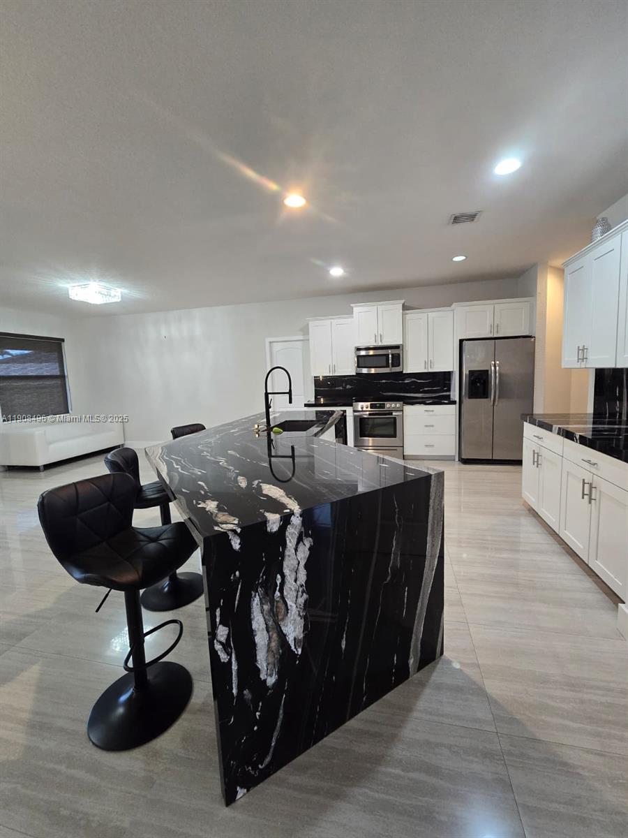 12944 Southwest 222nd Street Miami, FL 33170 - Photo 23 of 44 a kitchen with a sink stainless steel appliances and cabinets