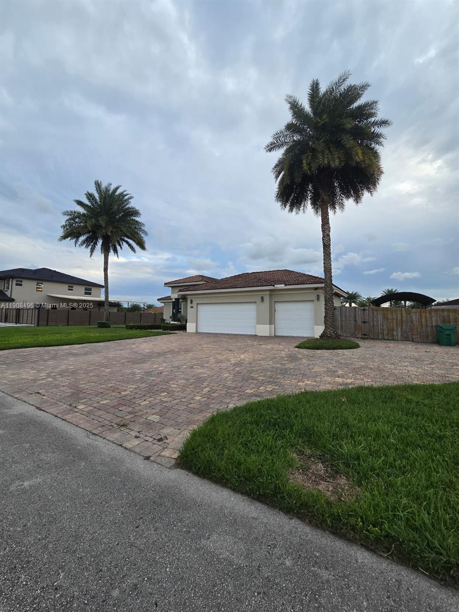 12944 Southwest 222nd Street Miami, FL 33170 - Photo 5 of 44 a palm tree sitting in front of a house with a yard