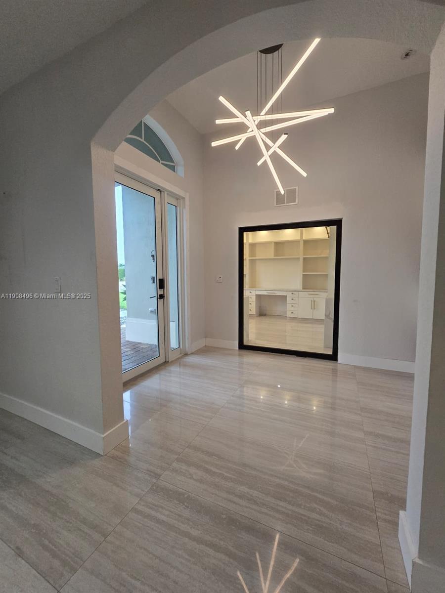 12944 Southwest 222nd Street Miami, FL 33170 - Photo 9 of 44 a view of an empty room with wooden floor and a ceiling fan