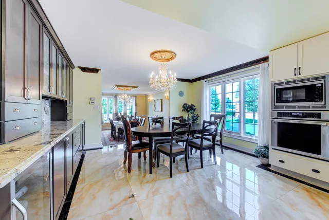 a view of a dining room with furniture a chandelier and a large window