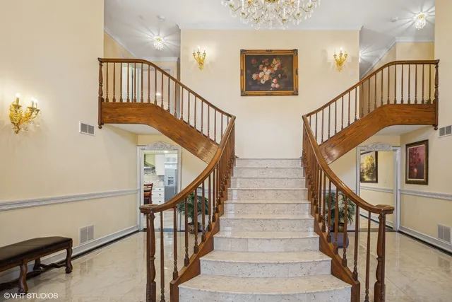 a view of staircase with lots of frames on wall and wooden floor