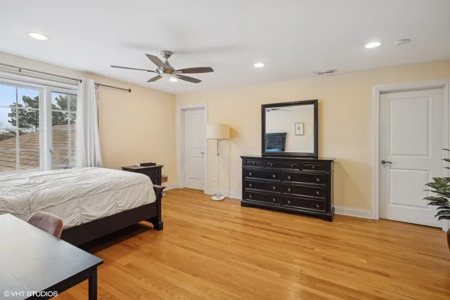 a bedroom with a bed and a dresser with mirror