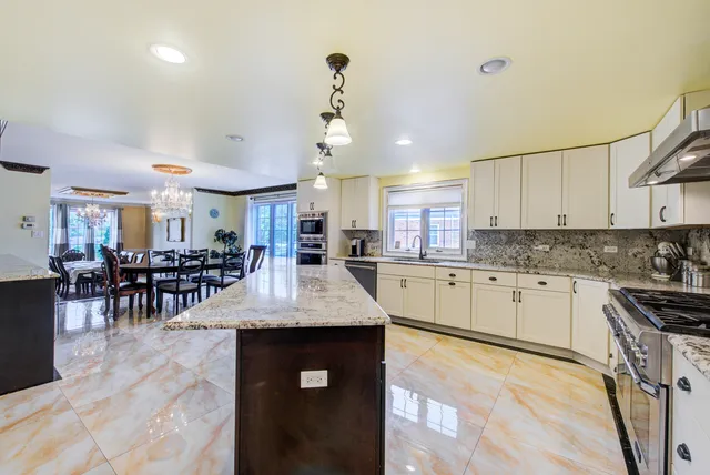 a kitchen with granite countertop a stove microwave and sink