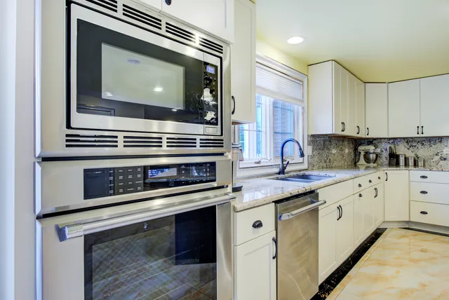 a kitchen with stainless steel appliances granite countertop a stove a sink a oven and a refrigerator