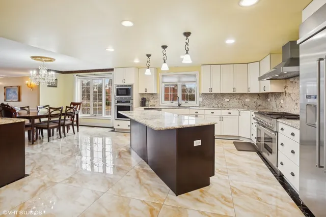 a large kitchen with kitchen island a sink stove and refrigerator