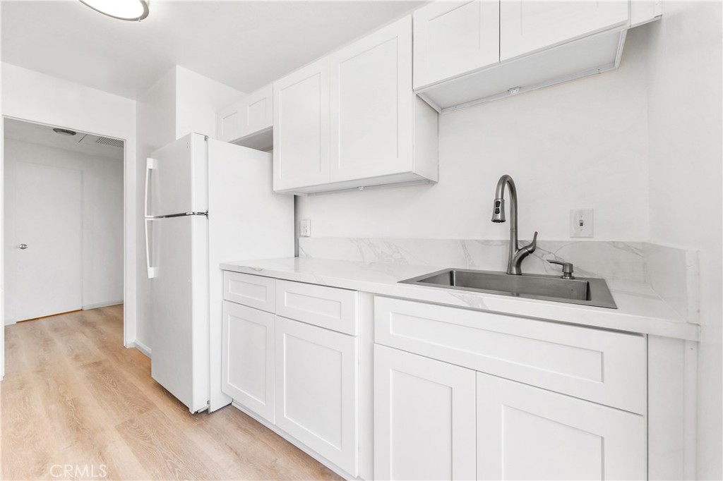 100 Atlantic Avenue, Unit 1005 Long Beach, CA 90802 - Photo 5 of 19 a kitchen with white cabinets and sink