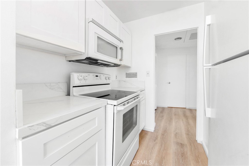 100 Atlantic Avenue, Unit 1005 Long Beach, CA 90802 - Photo 6 of 19 a kitchen with a stove oven and white cabinets