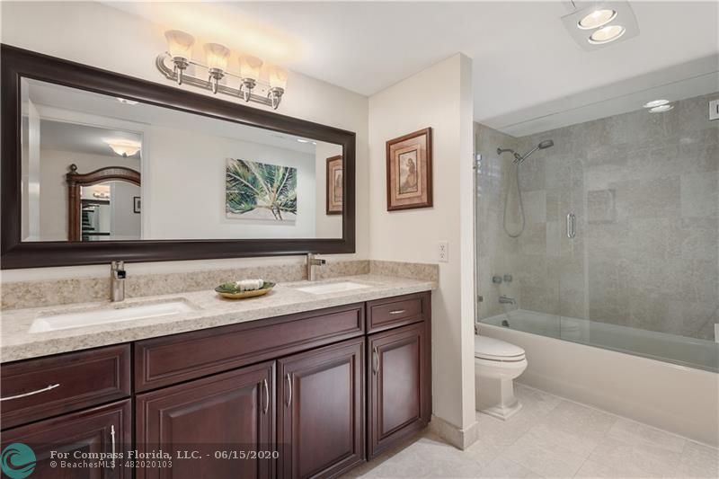3050 Northeast 47th Court, Unit 301 Fort Lauderdale, FL 33308 - Photo 11 of 19 a bath room with a toilet a sink and a large mirror