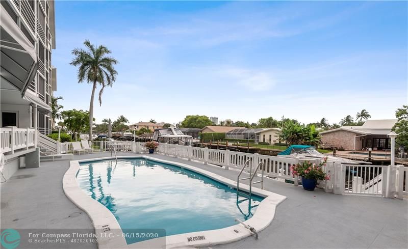 3050 Northeast 47th Court, Unit 301 Fort Lauderdale, FL 33308 - Photo 18 of 19 a view of a swimming pool with a lounge chair
