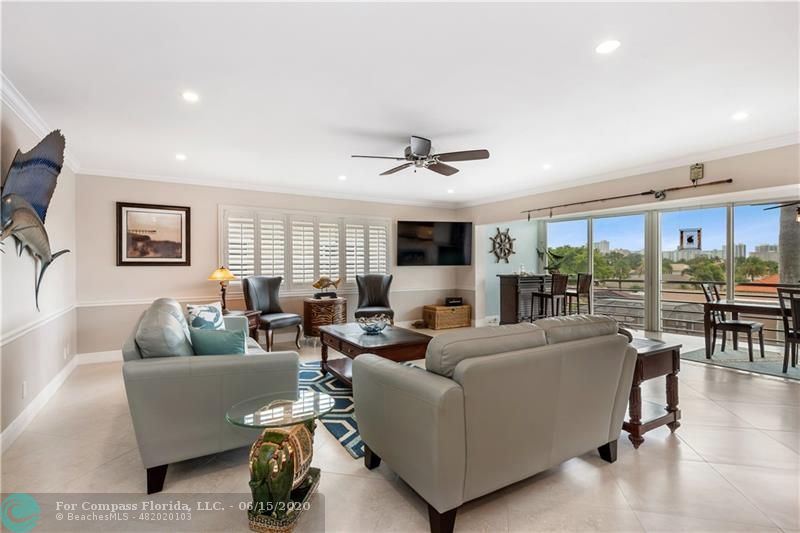3050 Northeast 47th Court, Unit 301 Fort Lauderdale, FL 33308 - Photo 2 of 19 a living room with furniture and a large window
