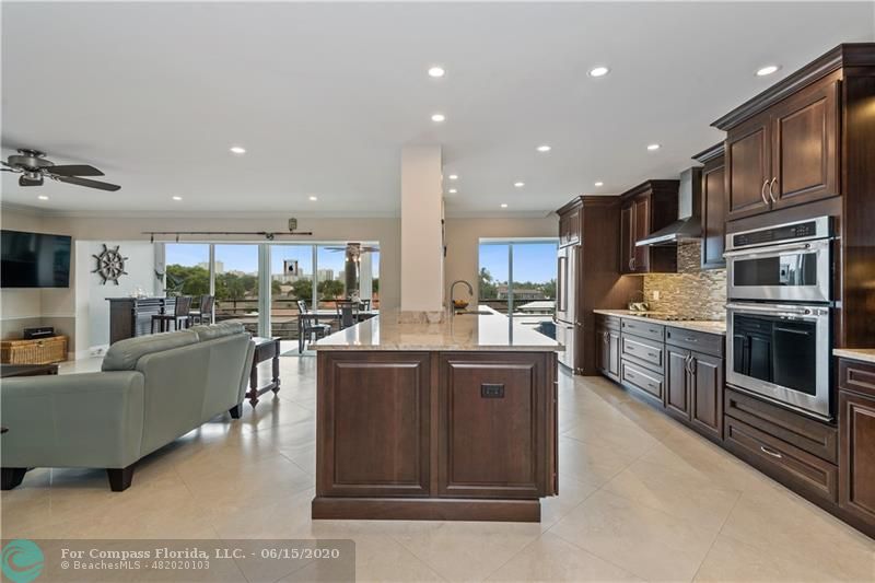 3050 Northeast 47th Court, Unit 301 Fort Lauderdale, FL 33308 - Photo 7 of 19 a living room with stainless steel appliances kitchen island granite countertop a refrigerator and cabinets