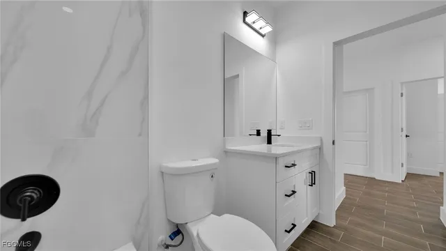 a bathroom with a sink mirror vanity and toilet