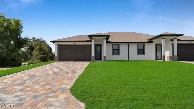 a front view of a house with a garden and yard