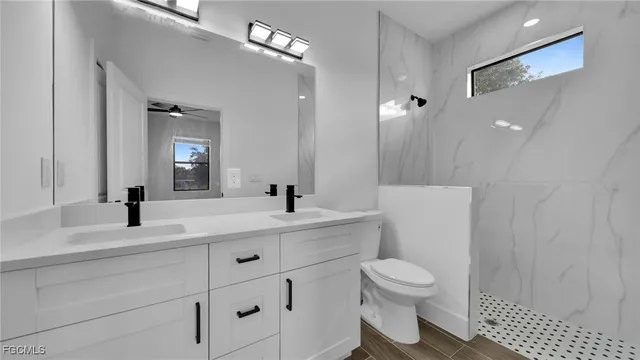 a bathroom with a sink a toilet and a large mirror