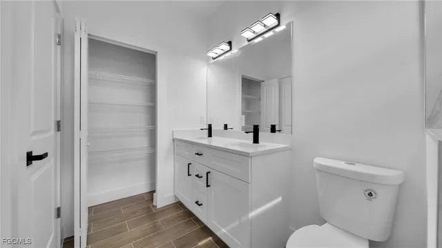 a bathroom with a sink vanity mirror and toilet