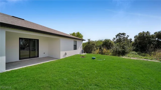 a view of a backyard with potted plants and large tree