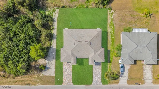 an aerial view of a house with a yard and lake view
