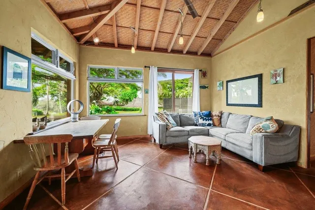 a living room with furniture a flat screen tv and a floor to ceiling window