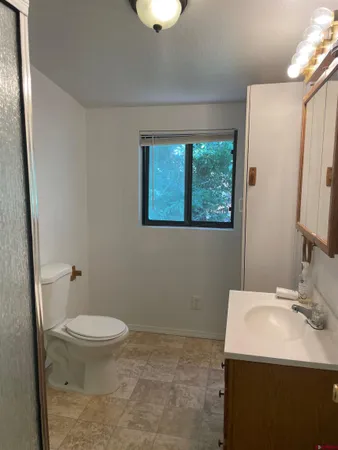 a bathroom with a sink a toilet and a mirror