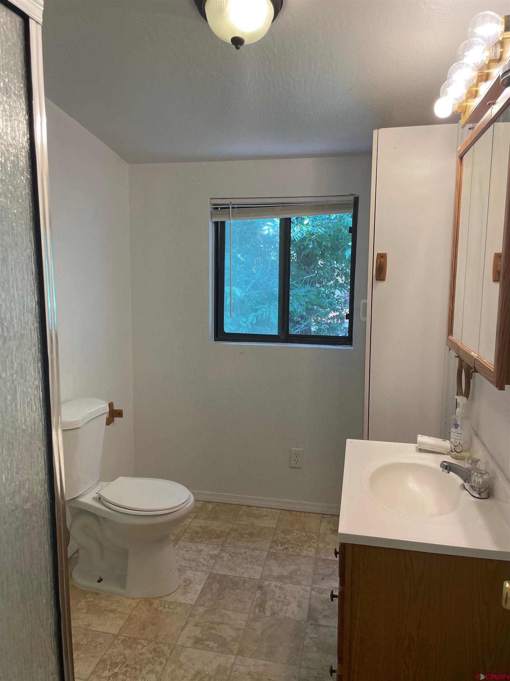 145 South Madison Street Cortez, CO 81321 - Photo 6 of 7 a bathroom with a sink a toilet and a mirror