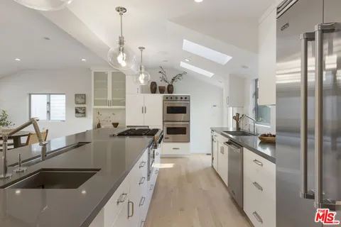 a kitchen with stainless steel appliances granite countertop a sink a stove and refrigerator