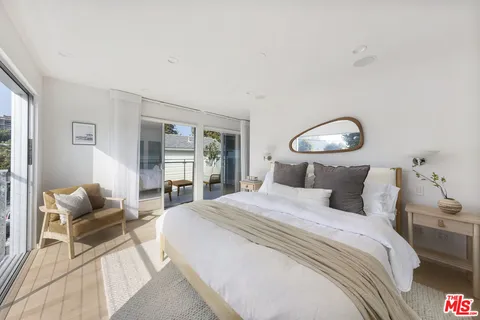 a bedroom with bed and a large window