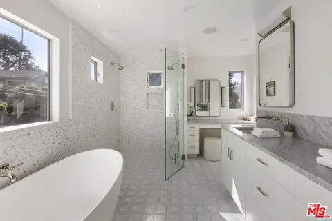a bathroom with a granite countertop sink mirror and a bathtub