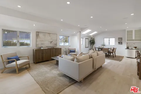 a living room with furniture and view of kitchen