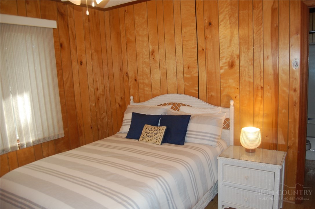 61 Dew Drop Loop Newland, NC 28657 - Photo 12 of 26 a bedroom with a bed and wooden floor