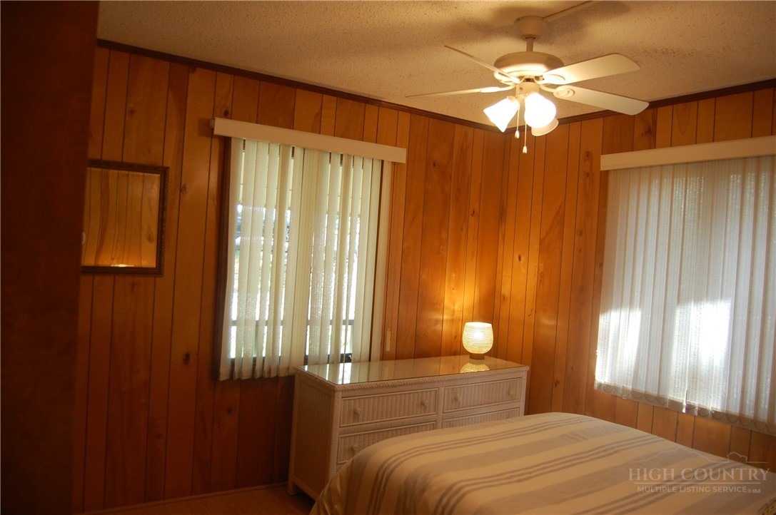 61 Dew Drop Loop Newland, NC 28657 - Photo 13 of 26 a bedroom with a bed and a chandelier