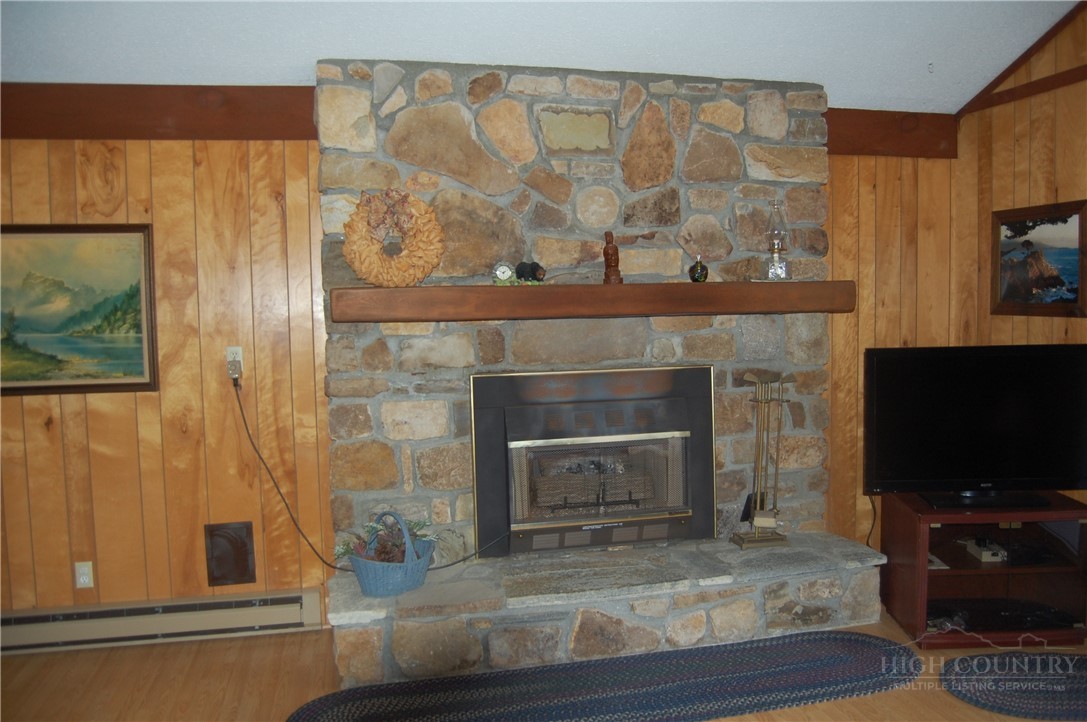 61 Dew Drop Loop Newland, NC 28657 - Photo 7 of 26 a living room with a fireplace and a flat screen tv