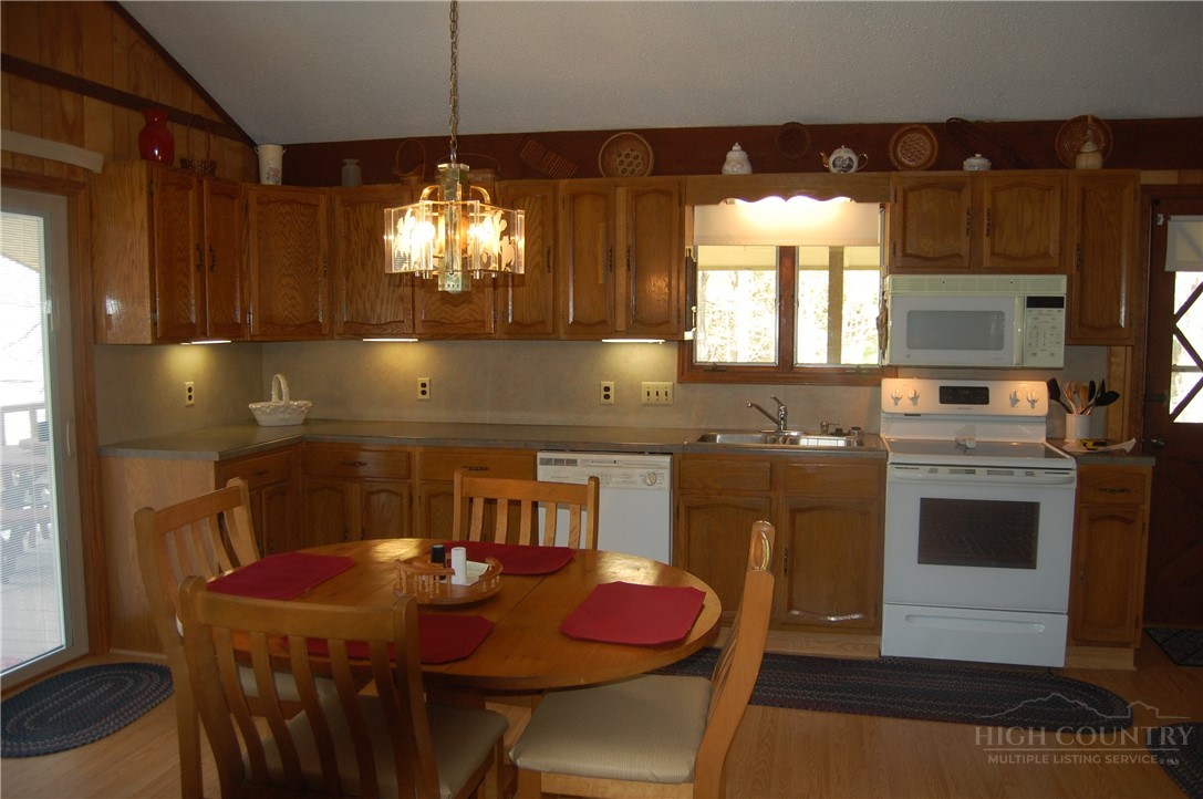 61 Dew Drop Loop Newland, NC 28657 - Photo 9 of 26 a kitchen with stainless steel appliances granite countertop a sink a stove a dining table and chairs