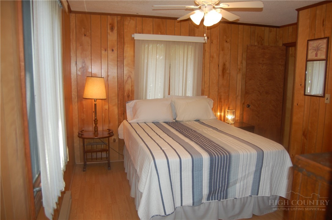 61 Dew Drop Loop Newland, NC 28657 - Photo 10 of 26 a bedroom with a bed and a chandelier