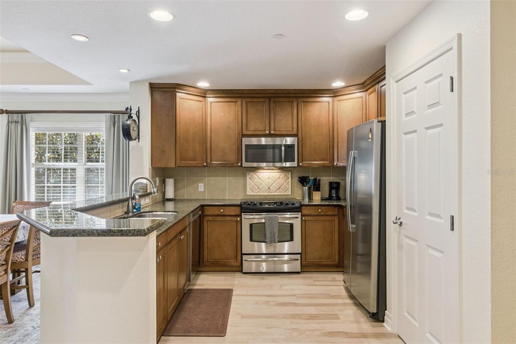 7650 Whisper Way, Unit 204 Reunion, FL 34747 - Photo 12 of 29 a kitchen with stainless steel appliances granite countertop a sink stove and refrigerator