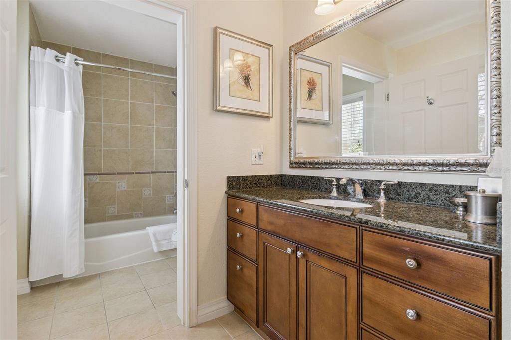 7650 Whisper Way, Unit 204 Reunion, FL 34747 - Photo 18 of 29 a bathroom with a granite countertop sink a mirror and a bathtub