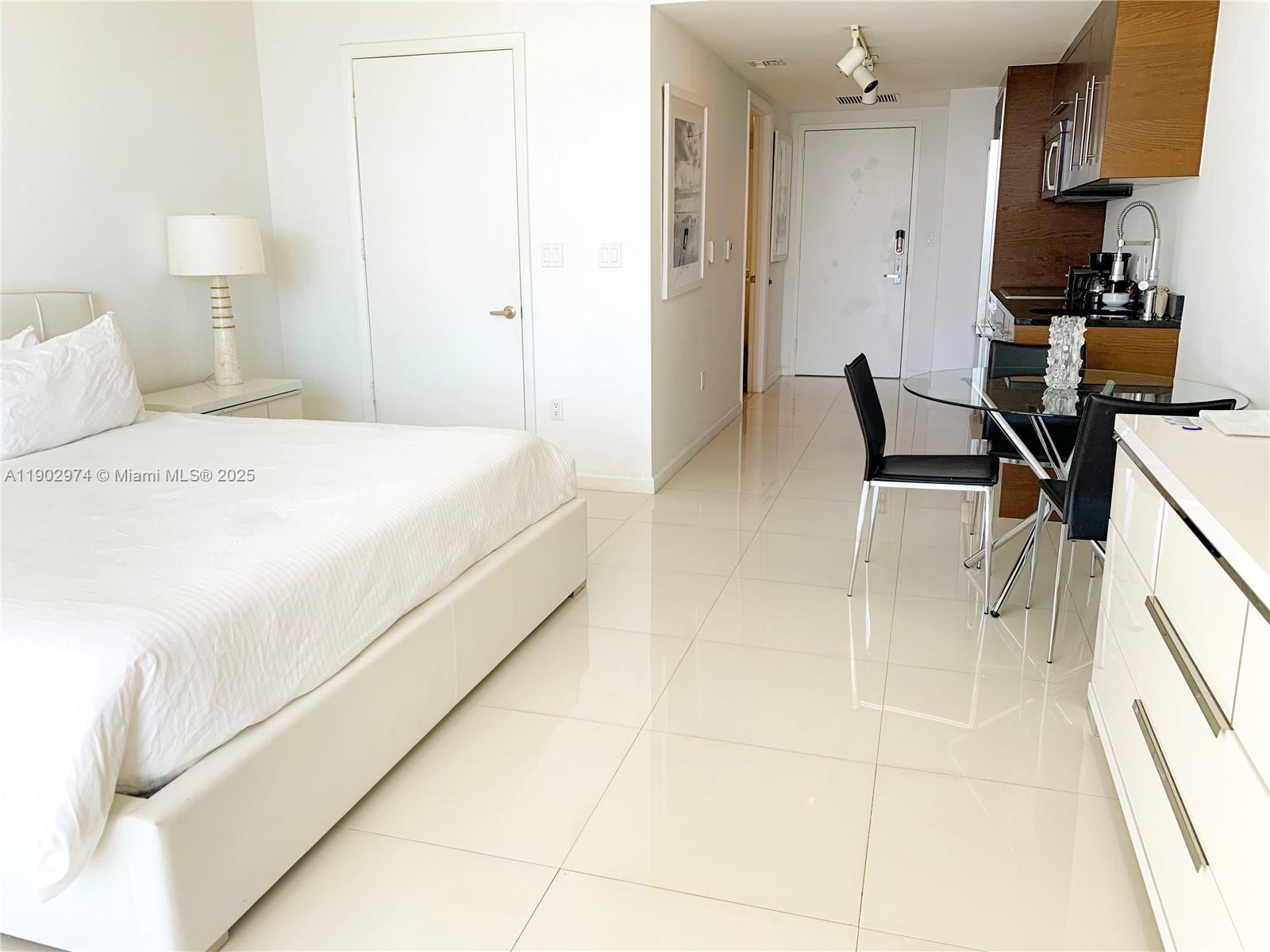 Icon Brickell Miami, FL 33131 - Photo 7 of 13 a spacious bedroom with a bed and a lamp