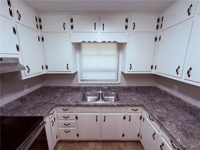 a close view of a kitchen sink and cabinets