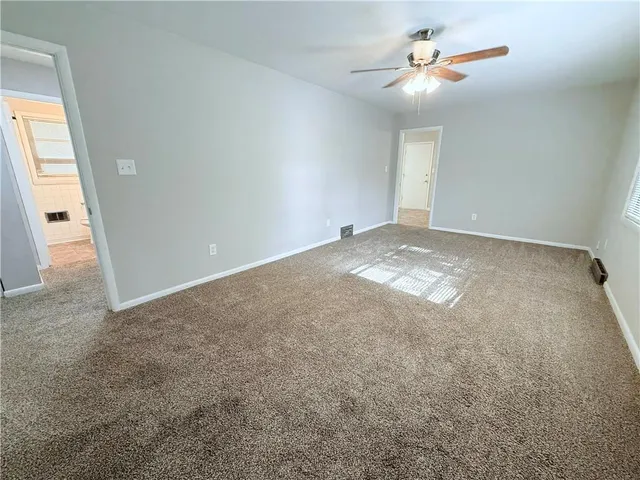 an empty room with fan and windows