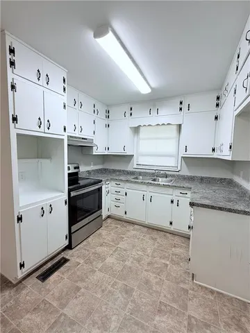a kitchen with granite countertop white cabinets and stainless steel appliances