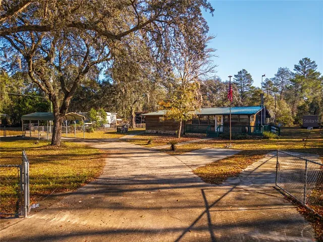 a view of a swimming pool with a lawn chairs under an umbrella
